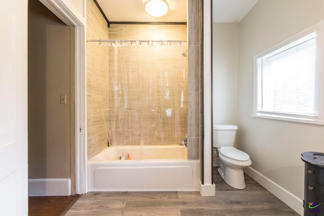 bathroom with toilet, tiled shower / bath combo, and hardwood / wood-style floors