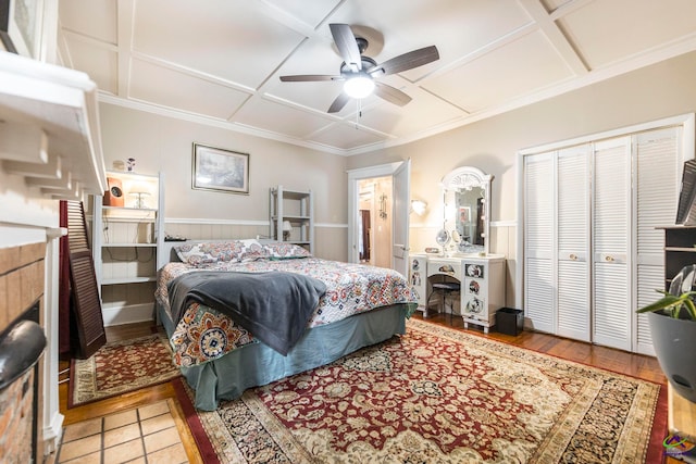 bedroom with coffered ceiling, hardwood / wood-style flooring, a closet, crown molding, and ceiling fan