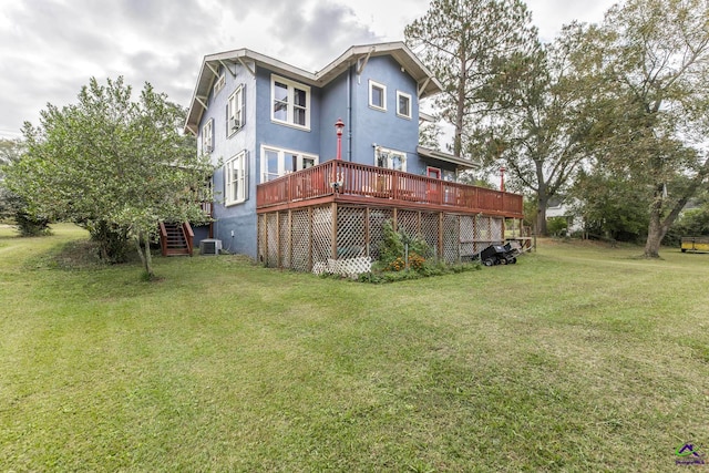 rear view of property with a yard, a deck, and central AC