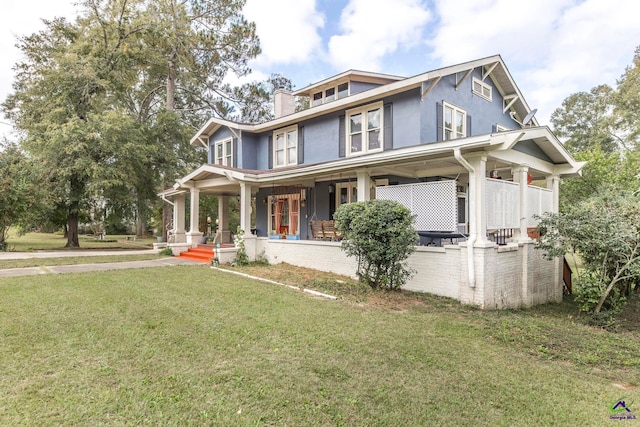 view of front facade with covered porch and a front yard