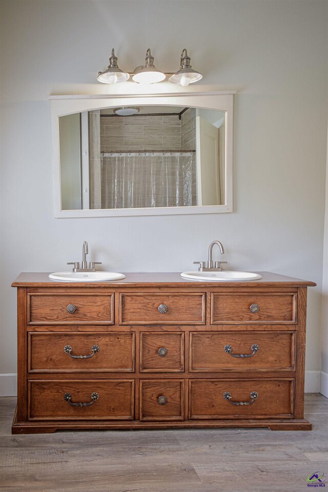 429 N Dooly St, Montezuma, GA 31063 - full bathroom featuring wood finished floors, baseboards, double vanity, and a shower with shower curtain
