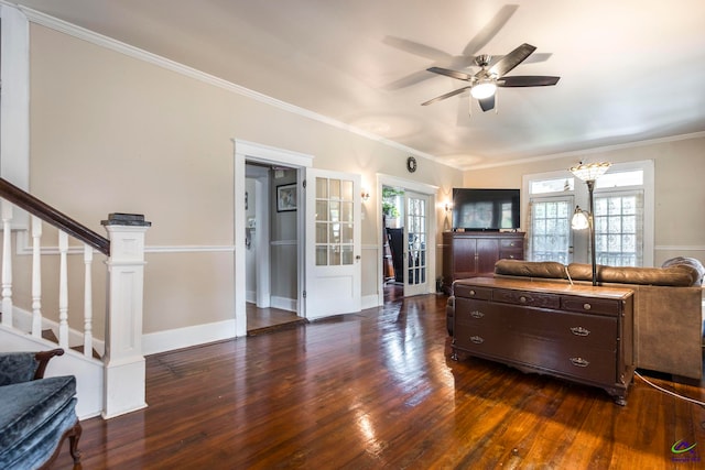 living room featuring ornamental molding, french doors, ceiling fan with notable chandelier, and dark hardwood / wood-style flooring