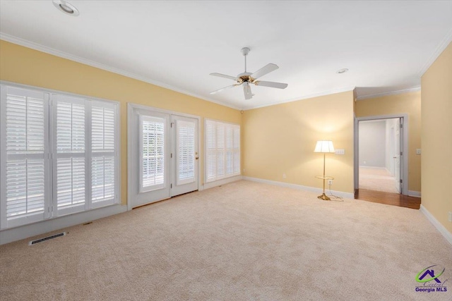 spare room with light colored carpet, ceiling fan, and crown molding