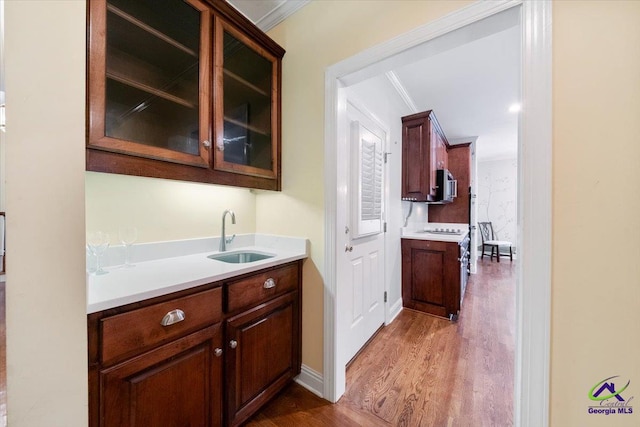 bar with crown molding, sink, and dark wood-type flooring