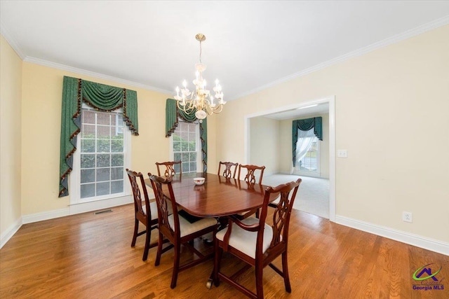 dining space with ornamental molding, a healthy amount of sunlight, and hardwood / wood-style flooring