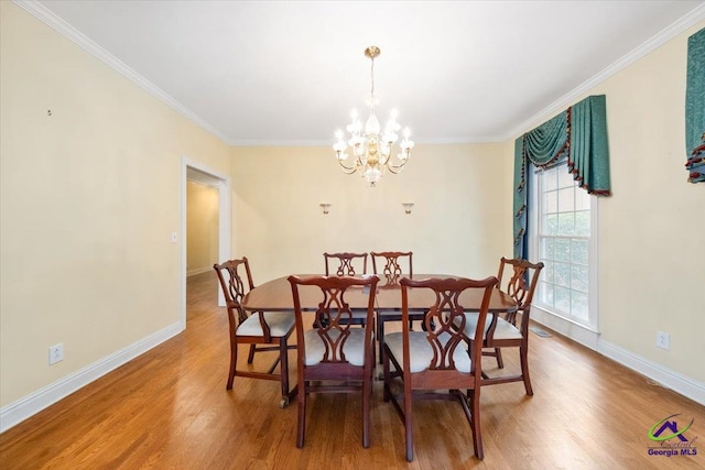 dining room featuring a chandelier, ornamental molding, and hardwood / wood-style flooring