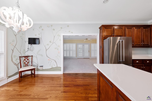 kitchen with hardwood / wood-style flooring, high end fridge, ornamental molding, and hanging light fixtures