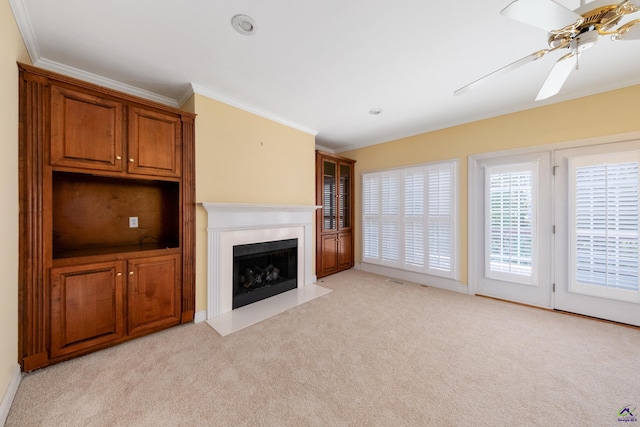 unfurnished living room with light carpet, ceiling fan, and ornamental molding