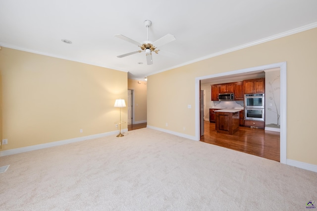 carpeted empty room featuring ceiling fan and crown molding