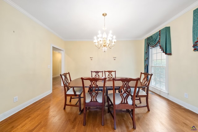 dining room featuring crown molding, a chandelier, and hardwood / wood-style flooring