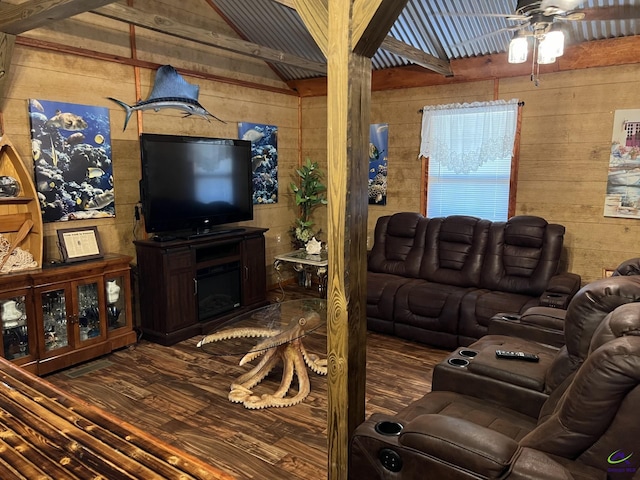 living room with wooden walls, lofted ceiling with beams, ceiling fan, and dark hardwood / wood-style flooring