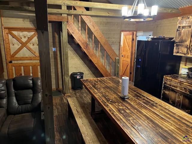 dining area featuring a notable chandelier and wood walls