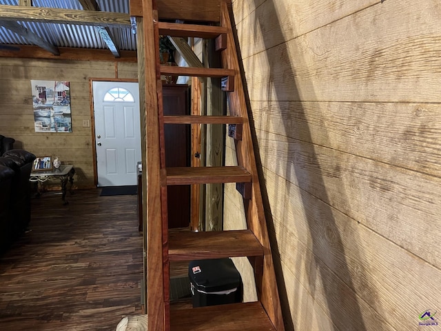 staircase featuring beamed ceiling, hardwood / wood-style flooring, and wood walls