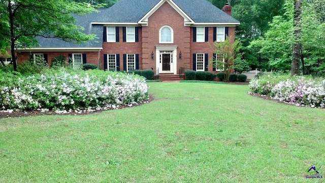 colonial house featuring a front lawn