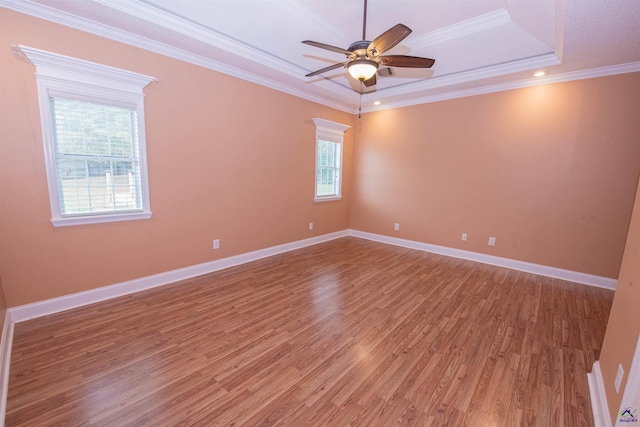 spare room featuring ceiling fan, crown molding, a raised ceiling, and hardwood / wood-style floors