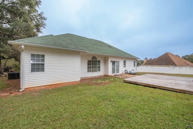 back of house featuring a wooden deck and a lawn