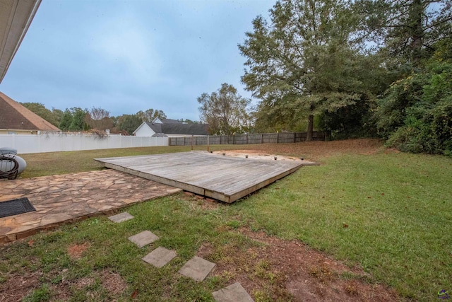 view of yard featuring a deck with water view and a patio area