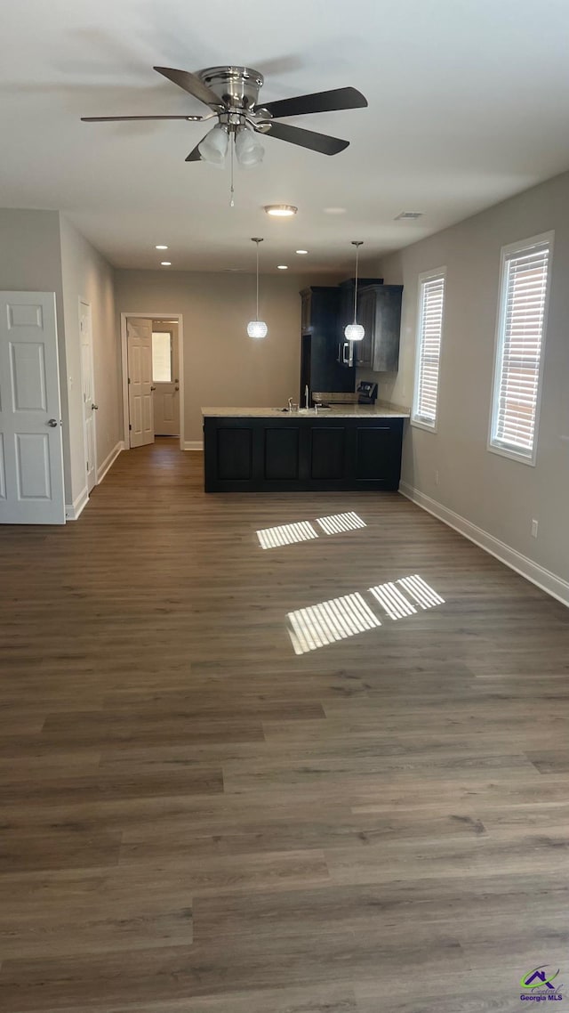 unfurnished living room featuring dark hardwood / wood-style flooring and ceiling fan