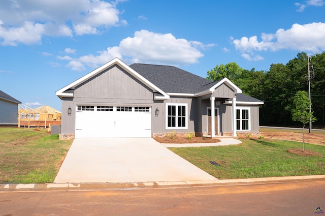 100 Saraland Trl, Perry, GA 31069 - view of front of house featuring an attached garage, a front yard, board and batten siding, and driveway