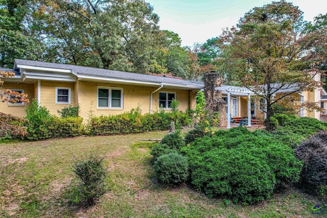 single story home featuring a pergola and a front lawn