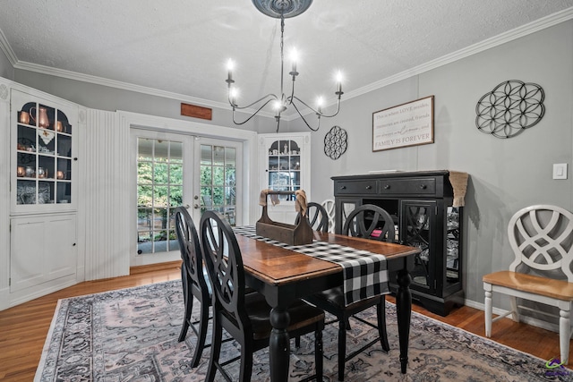 dining room featuring french doors, a textured ceiling, crown molding, and wood-type flooring