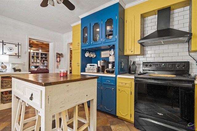 kitchen with blue cabinetry, wall chimney range hood, tasteful backsplash, black / electric stove, and ornamental molding