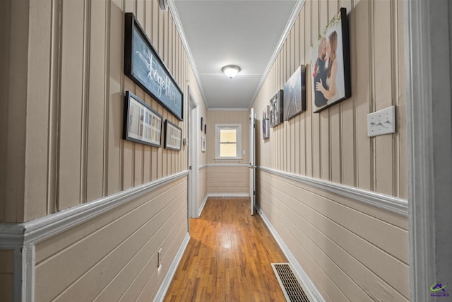 corridor featuring light hardwood / wood-style flooring and crown molding