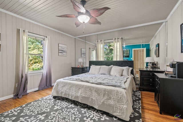 bedroom featuring light hardwood / wood-style flooring, ceiling fan, and crown molding