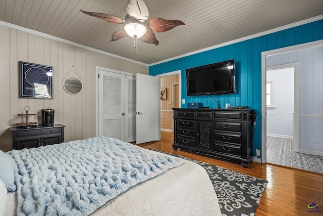 bedroom with hardwood / wood-style floors, a closet, ceiling fan, and ornamental molding