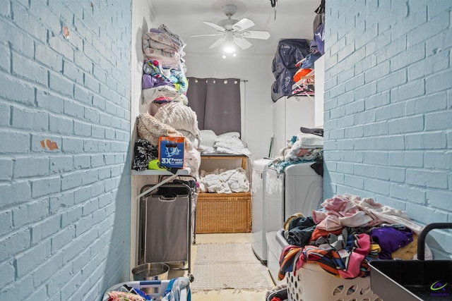 laundry room with washer and dryer, ceiling fan, and brick wall