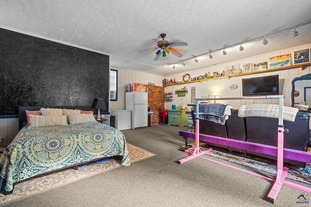 carpeted bedroom featuring a textured ceiling, white fridge, ceiling fan, and crown molding