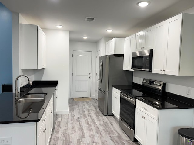 kitchen featuring white cabinets, sink, light hardwood / wood-style floors, and stainless steel appliances