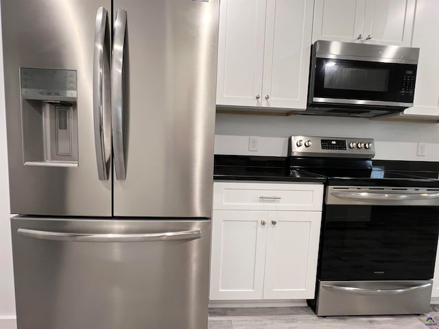 kitchen featuring white cabinetry, appliances with stainless steel finishes, and light hardwood / wood-style floors