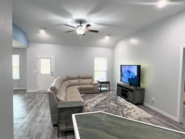 living room with hardwood / wood-style floors, ceiling fan, and lofted ceiling