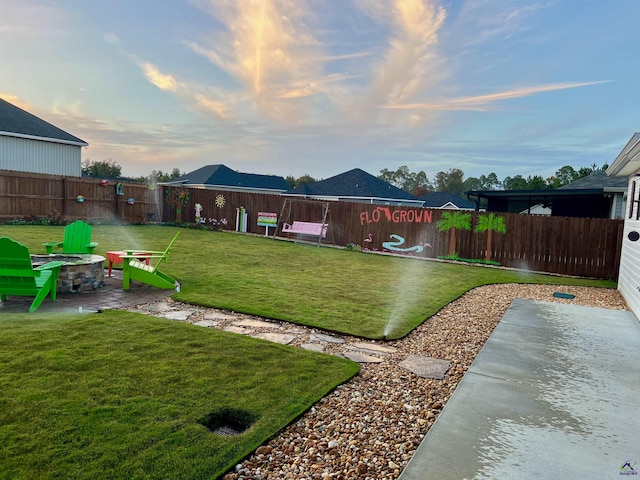 yard at dusk featuring a patio area and an outdoor fire pit