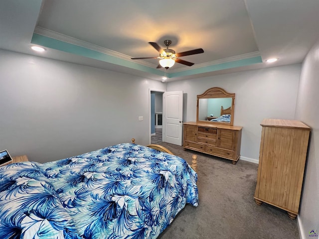 carpeted bedroom with a tray ceiling, ceiling fan, and crown molding