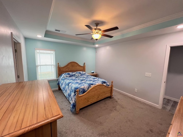 bedroom with ceiling fan, ornamental molding, carpet flooring, and a tray ceiling