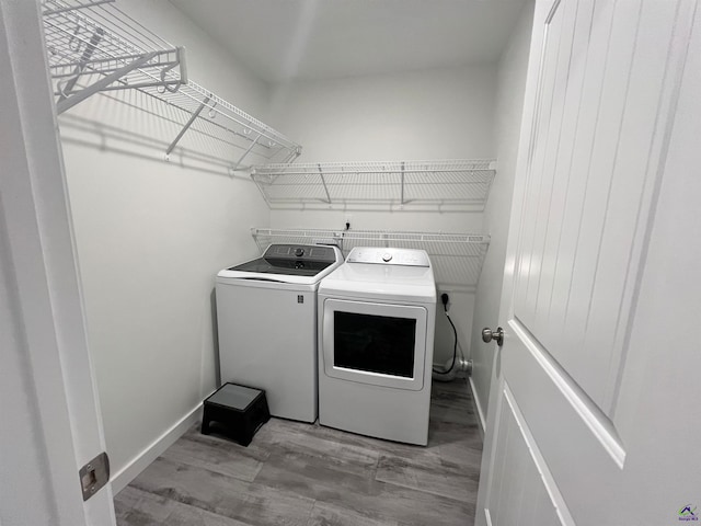 washroom featuring washing machine and dryer and light hardwood / wood-style flooring