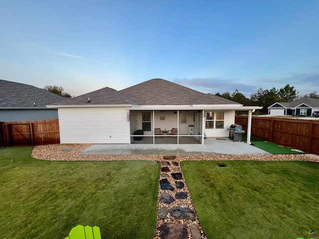 rear view of property with a lawn and a patio