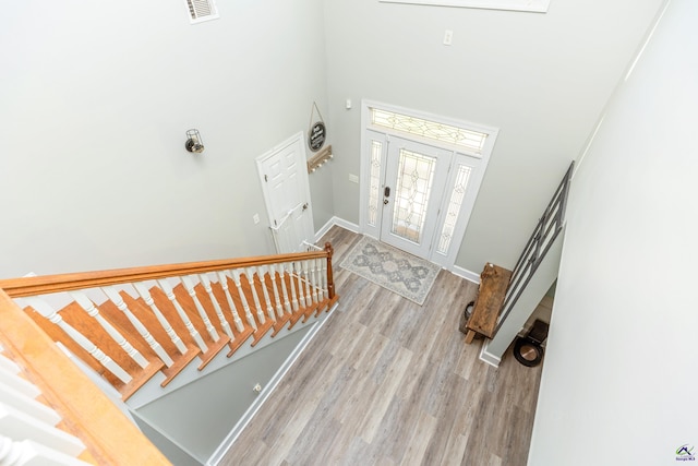 foyer featuring a towering ceiling and light hardwood / wood-style flooring