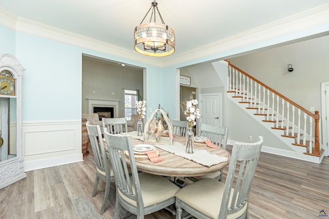 dining room with hardwood / wood-style flooring, an inviting chandelier, and crown molding