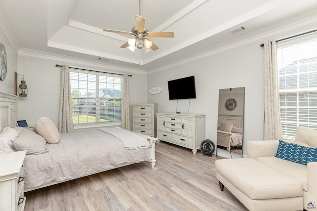 bedroom featuring ornamental molding, multiple windows, ceiling fan, and light wood-type flooring