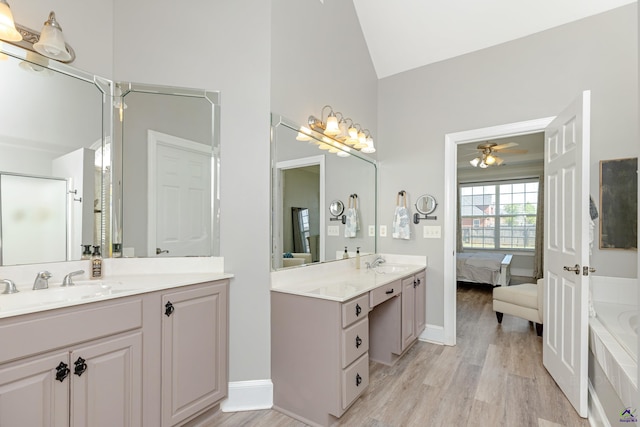 bathroom featuring ceiling fan, wood-type flooring, vanity, lofted ceiling, and separate shower and tub