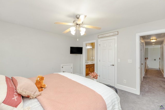 bedroom with ensuite bath, light carpet, and ceiling fan