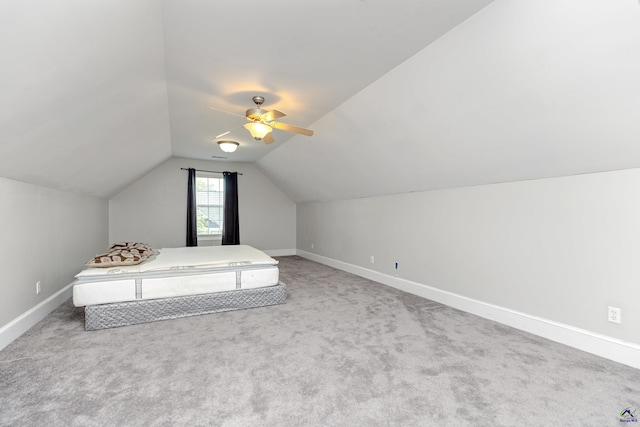 unfurnished bedroom featuring carpet, lofted ceiling, and ceiling fan