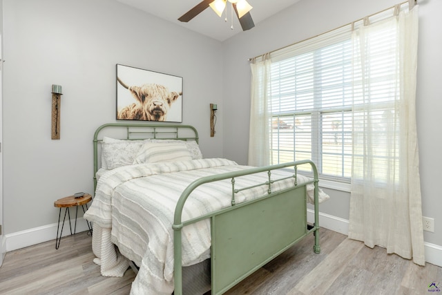 bedroom featuring light hardwood / wood-style flooring, multiple windows, and ceiling fan