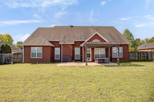 rear view of property featuring a pergola, a yard, and a patio area