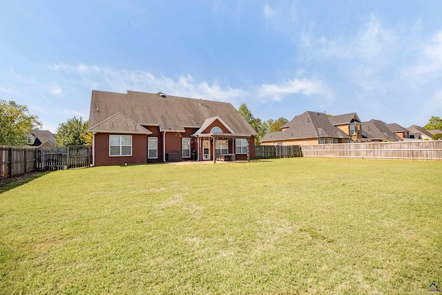 rear view of house featuring a yard