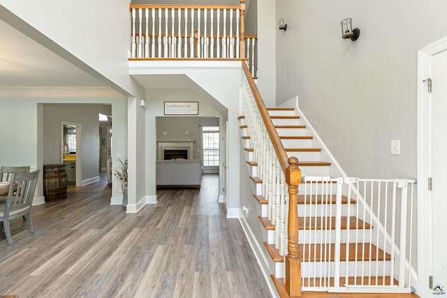 stairs with a high ceiling and wood-type flooring