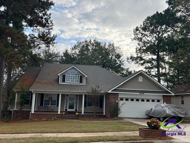 view of front of house featuring a front lawn, a garage, and covered porch